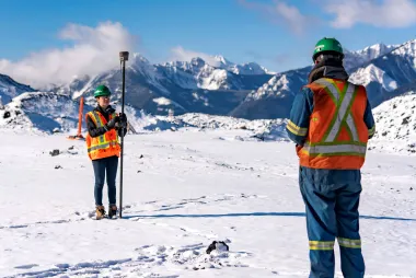 Two students doing work on a snowy mountain