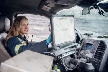 Mining engineer using laptop inside a vehicle.