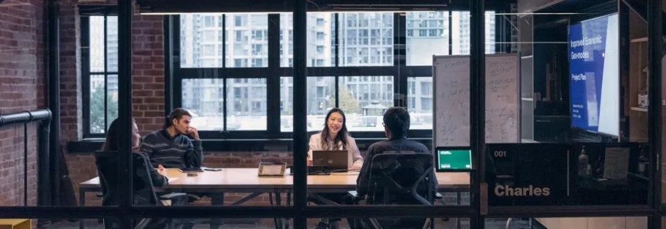 Four people in a modern meeting room.