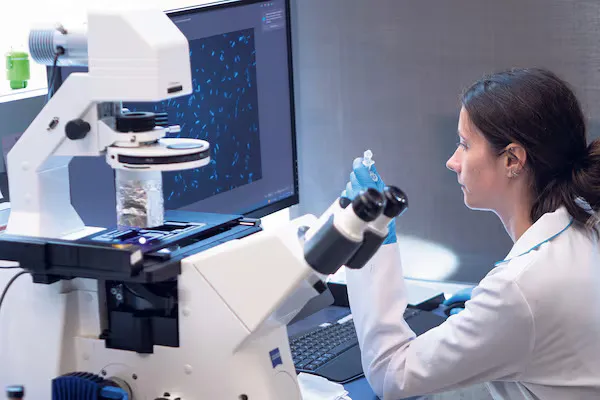 A PhD student in the Hallam lab examines blue-green algae cultures through an open-light incubator. Blue-green algae can provide clues about ecosystem health.
